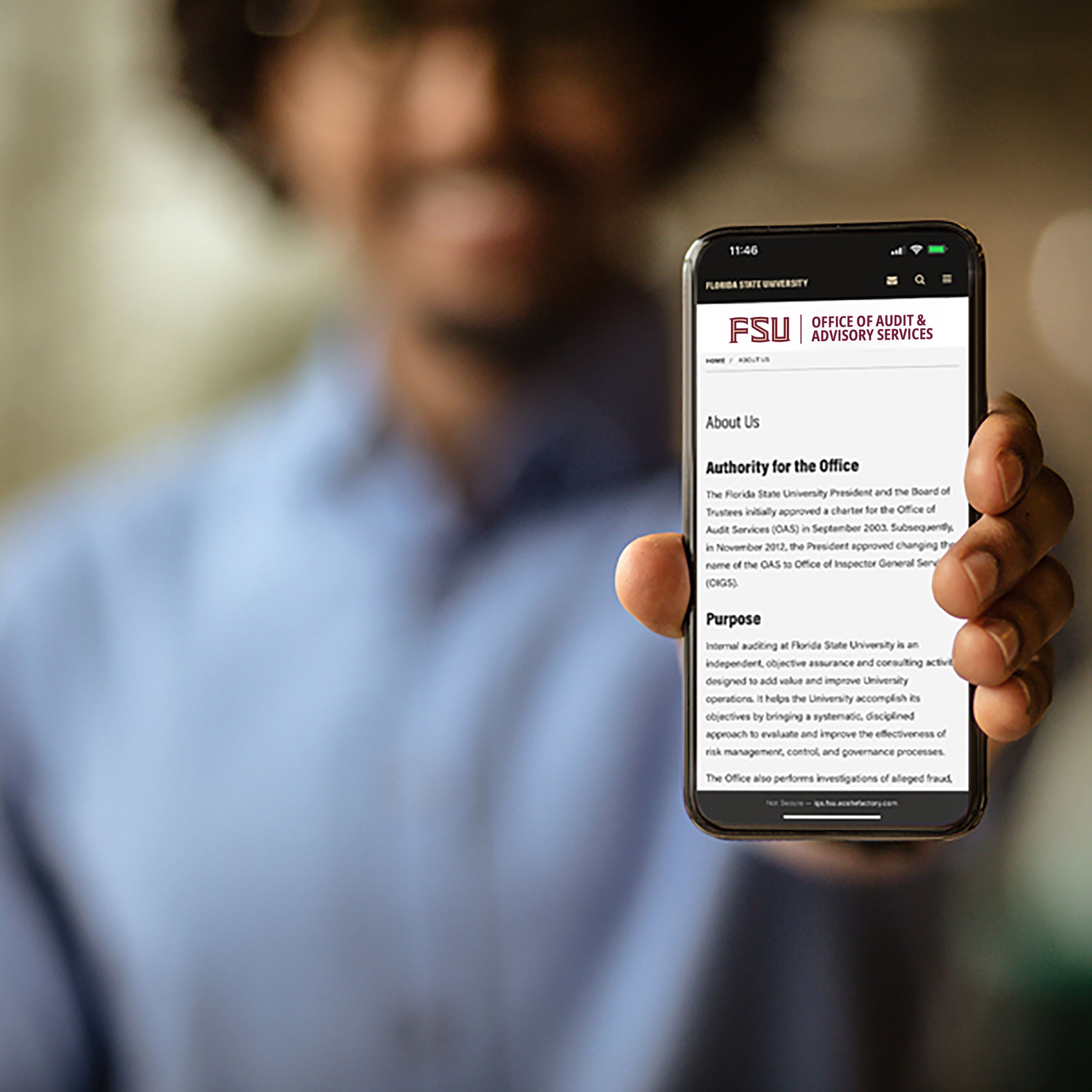 Photo of a man holding up a phone.